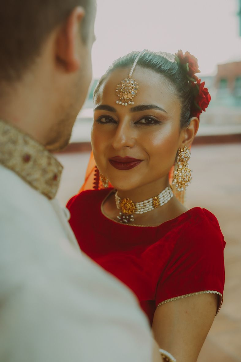 Close-ups van bruid in rode Indiase huwelijkskleding met ornamentele juwelen