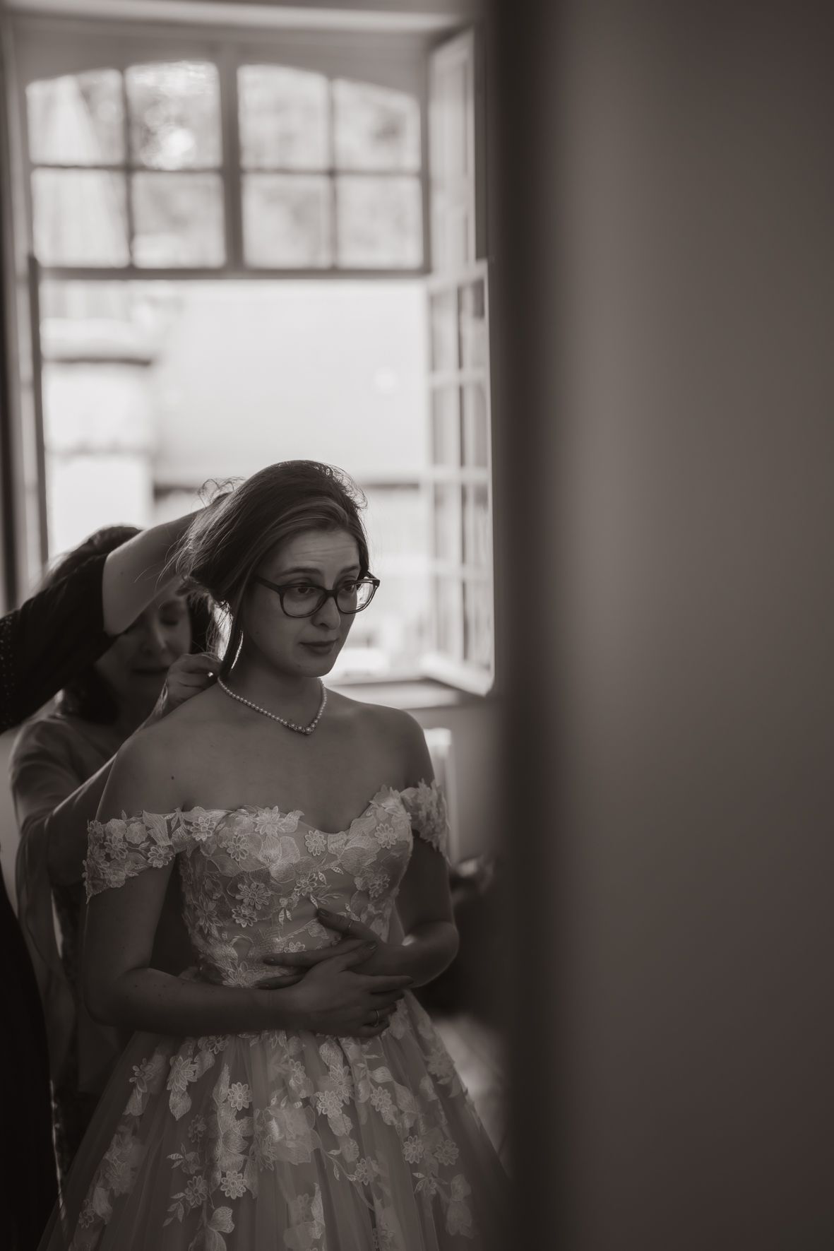 Zwart-wit voorbereiding bruiloft door raamkozijnen