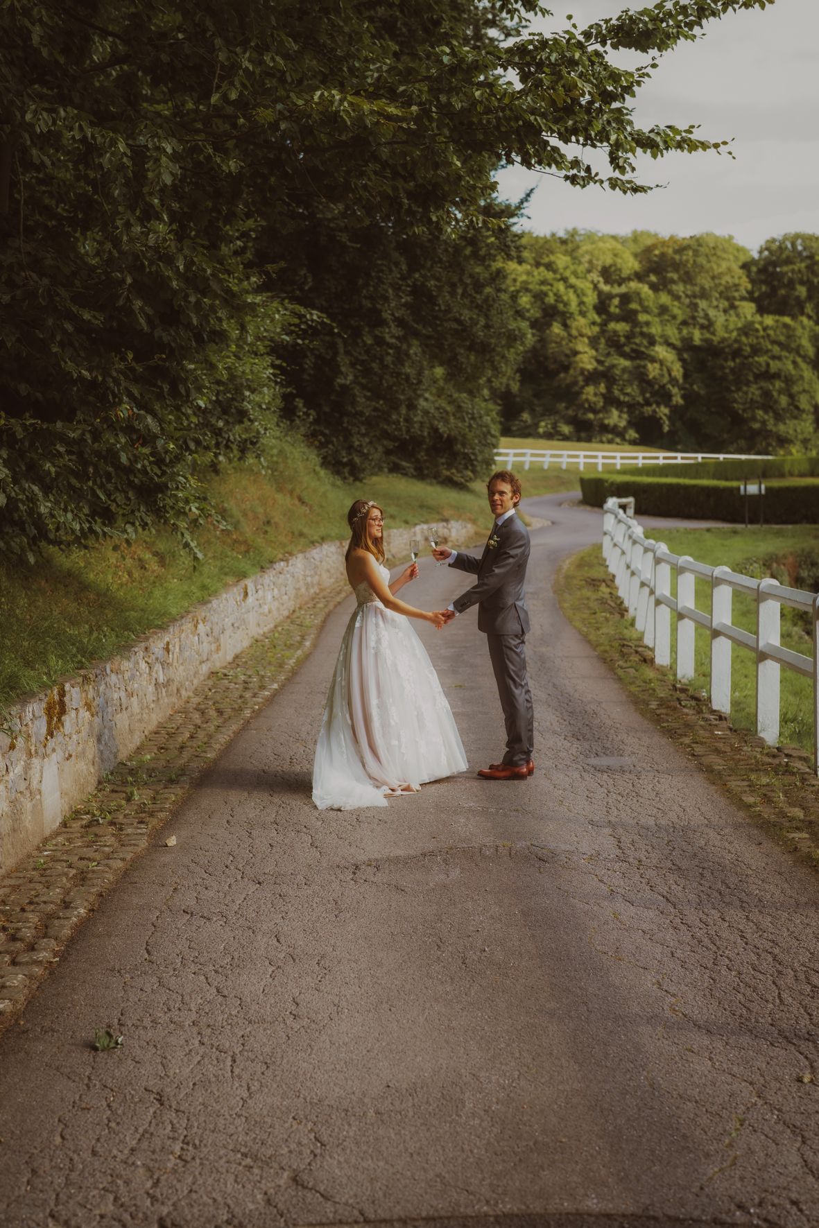 Trouwkoppel op een pad met witte omheining