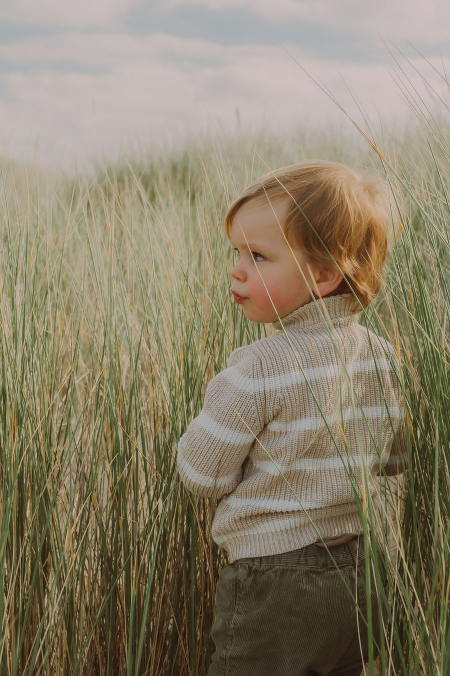 Kind in crème trui bij duingras