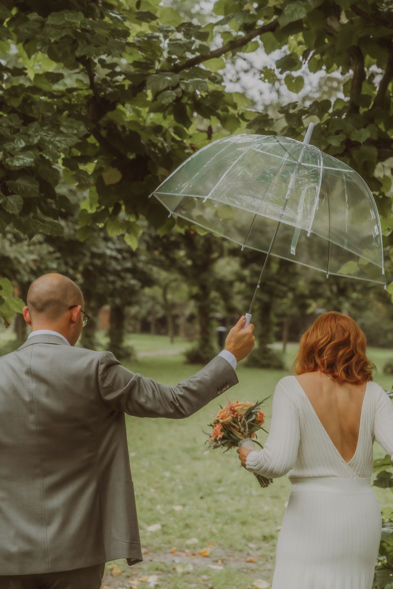 Trouwkoppel met paraplu in de regen