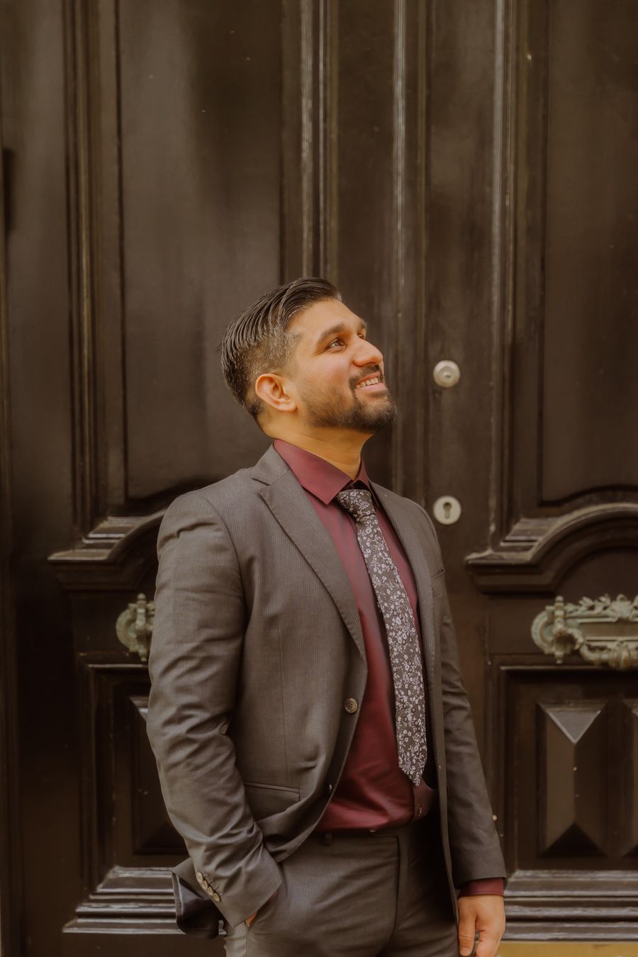 Portret van persoon in grijs pak met bordeaux stropdas