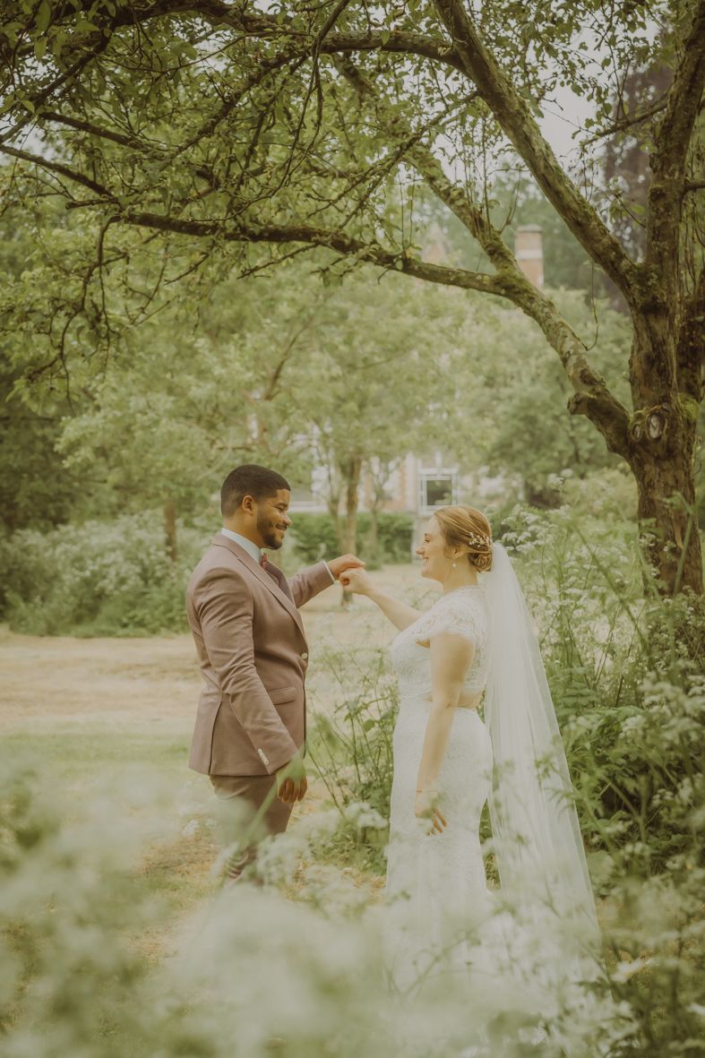 Koppel deelt een innig moment onder boomtakken in een tuin