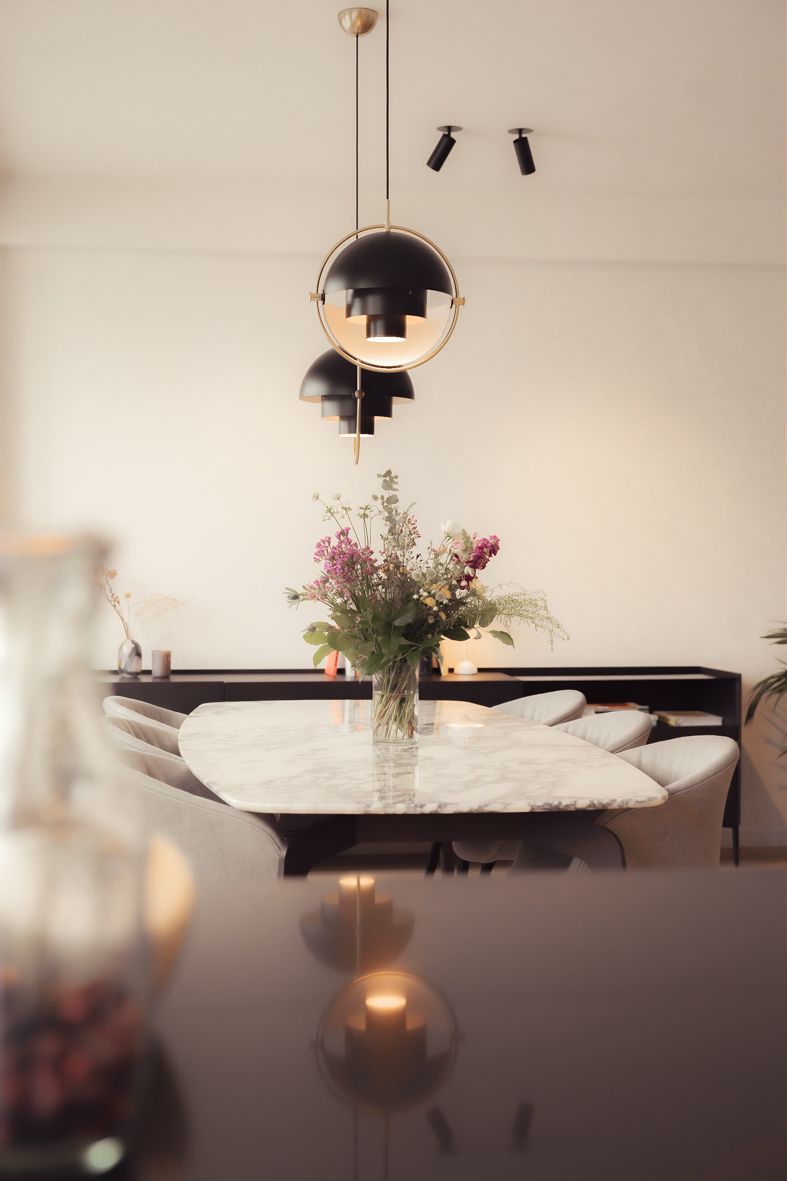 Minimalistische eetkamer met hanglampen en verse bloemen