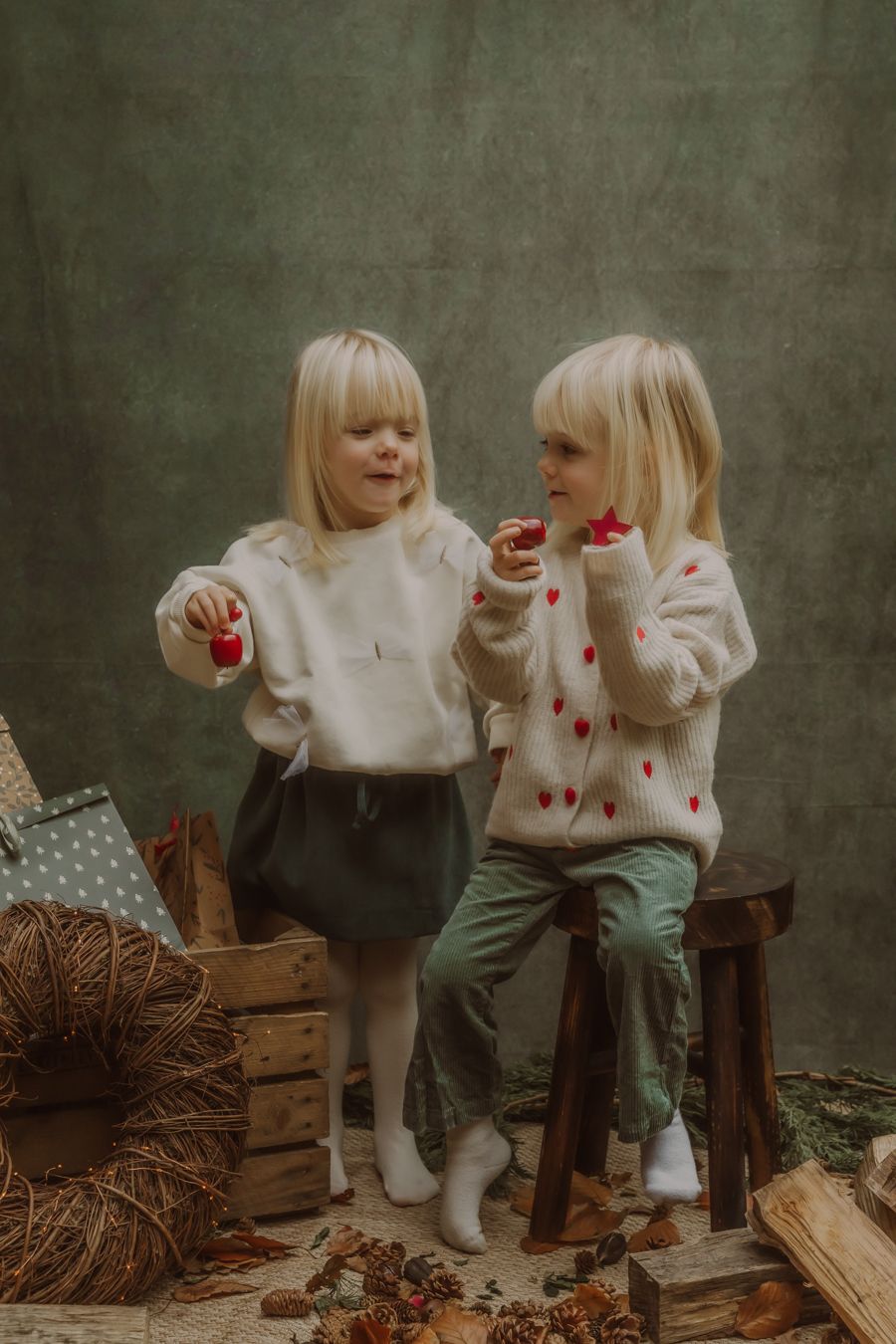Twee peuters in witte truitjes eten samen een snack