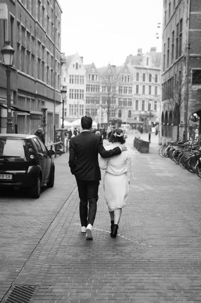 Zwart-wit foto van koppel wandelend op kasseienstraat in historische stad