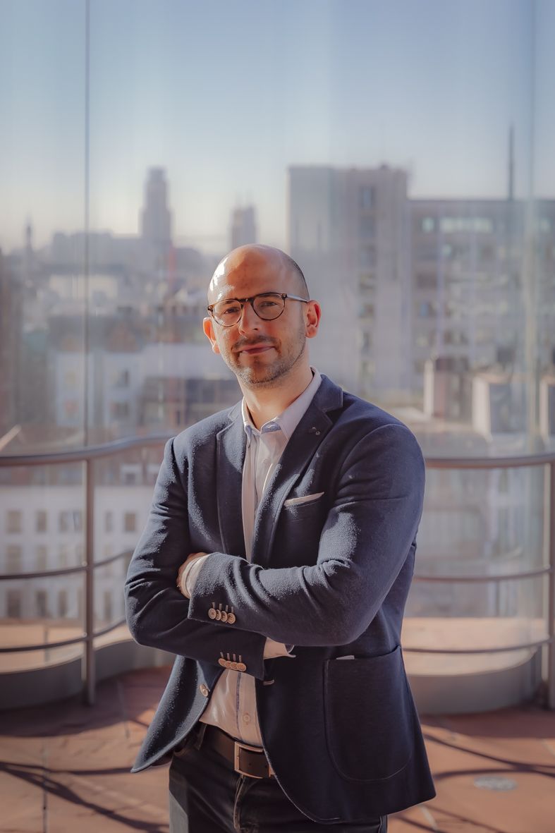 Professioneel portret op stadsrooftop in donker pak met bril