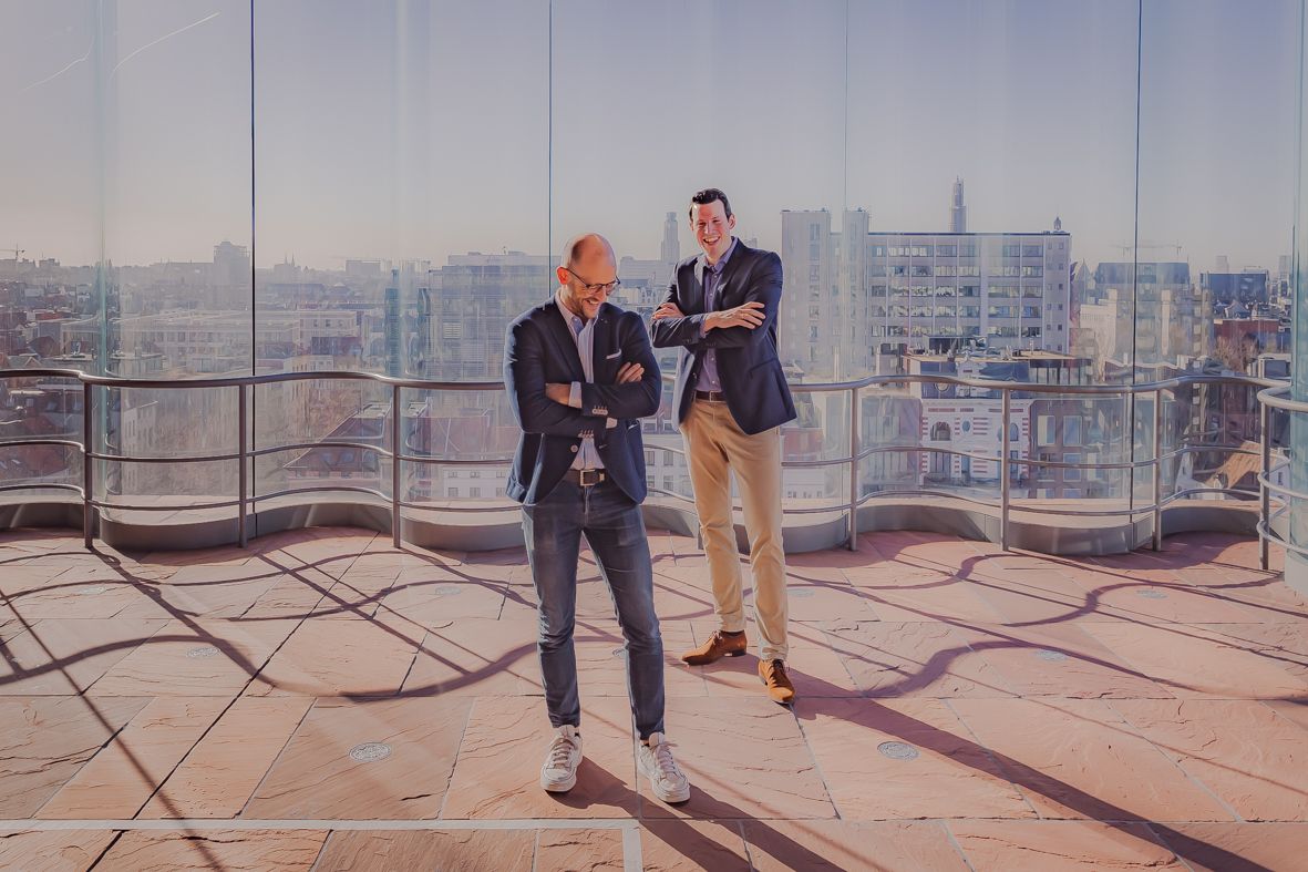 Twee mensen in zakelijke kleding overleggen met zicht op de stad